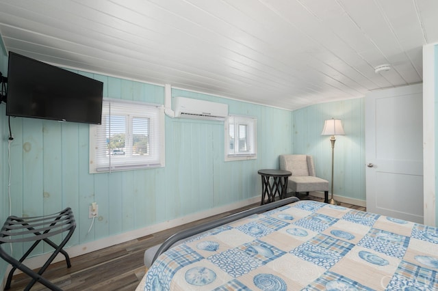 bedroom featuring an AC wall unit, wood finished floors, and baseboards