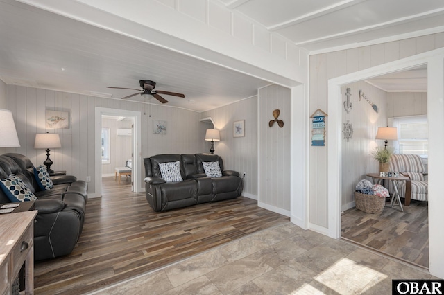 living room with wood finished floors, a ceiling fan, and baseboards