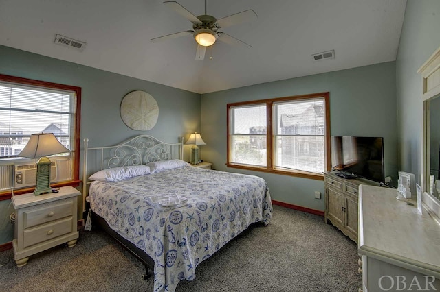 bedroom featuring lofted ceiling, multiple windows, dark carpet, and visible vents