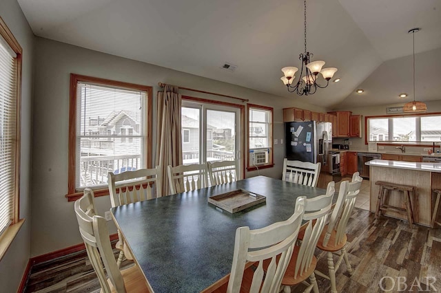 dining room with dark wood-style flooring, a notable chandelier, lofted ceiling, visible vents, and baseboards