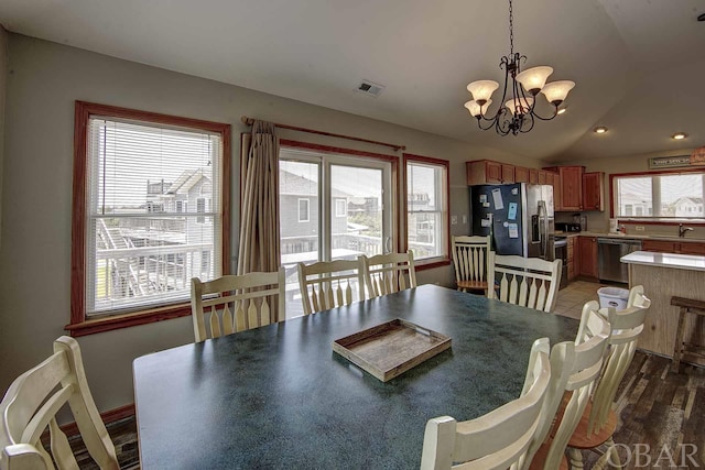 dining space featuring dark wood finished floors, lofted ceiling, recessed lighting, visible vents, and an inviting chandelier