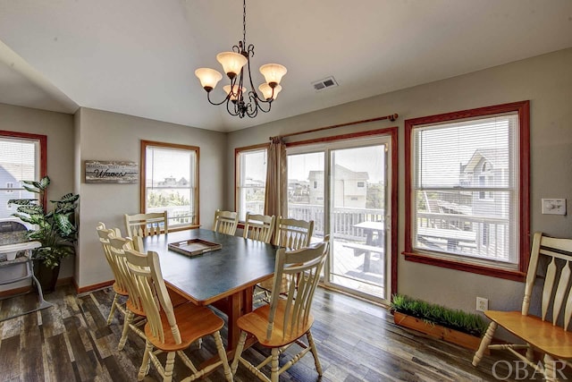 dining area featuring dark wood-style floors, baseboards, visible vents, and an inviting chandelier