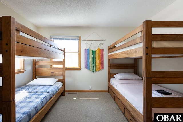 bedroom with a textured ceiling, carpet, and baseboards