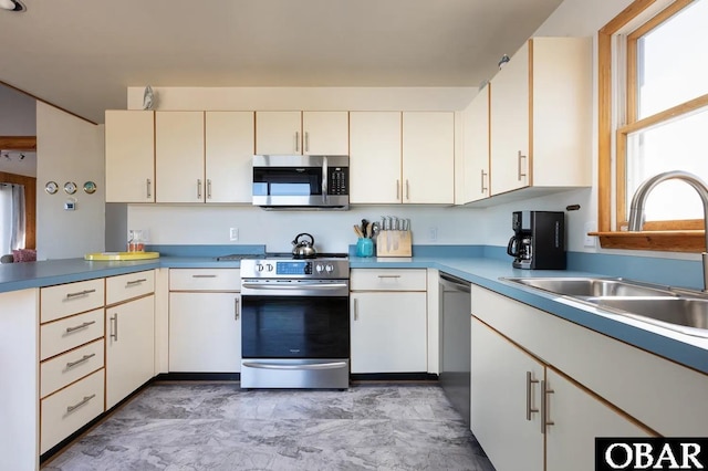 kitchen featuring stainless steel appliances, a sink, and a peninsula