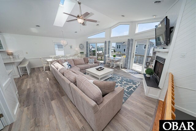 756 Mariner Dr Lot 2, Corolla, NC 27927 - living area featuring a ceiling fan, wood finished floors, lofted ceiling, healthy amount of natural light, and a wainscoted wall