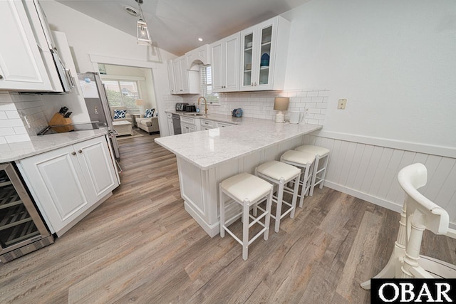 756 Mariner Dr Lot 2, Corolla, NC 27927 - kitchen with wine cooler, a sink, a kitchen breakfast bar, white cabinetry, and glass insert cabinets