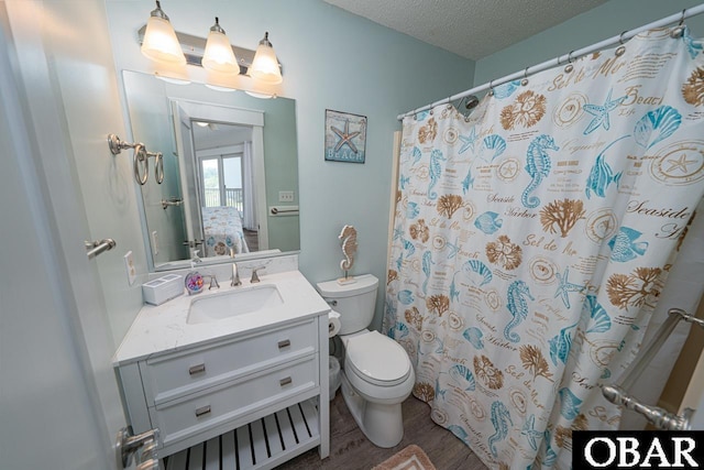756 Mariner Dr Lot 2, Corolla, NC 27927 - bathroom with toilet, vanity, wood finished floors, a textured ceiling, and curtained shower
