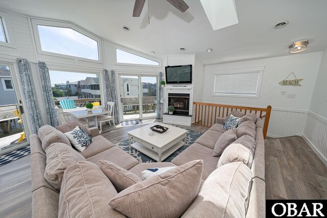 756 Mariner Dr Lot 2, Corolla, NC 27927 - living area featuring ceiling fan, vaulted ceiling, wood finished floors, a skylight, and wainscoting