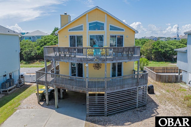 756 Mariner Dr Lot 2, Corolla, NC 27927 - view of front facade with a carport, a deck, a chimney, stairway, and concrete driveway