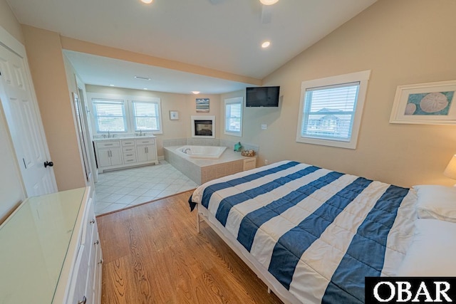 25259 Sea Isle Hills Dr Lot 7, Waves, NC 27982 - bedroom featuring recessed lighting, vaulted ceiling, light wood finished floors, a multi sided fireplace, and a sink