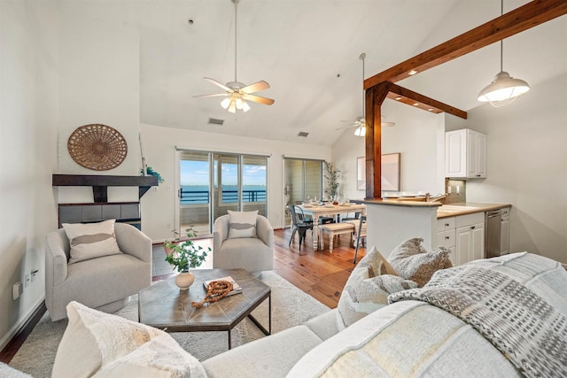 living room with light wood finished floors, a water view, visible vents, high vaulted ceiling, and beamed ceiling