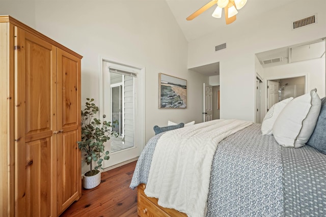 bedroom featuring high vaulted ceiling, wood finished floors, and visible vents