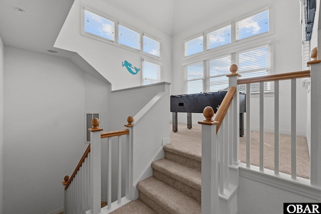 stairway featuring baseboards and carpet floors