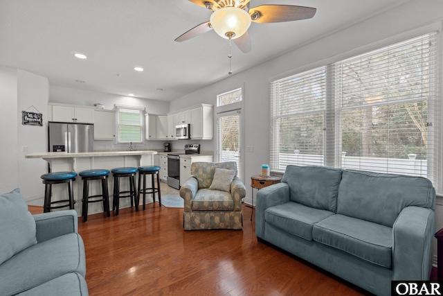 living area with recessed lighting, a ceiling fan, and dark wood-style flooring