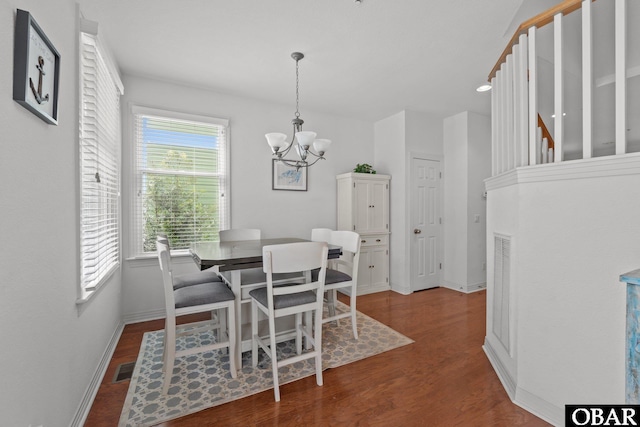 dining room featuring an inviting chandelier, wood finished floors, baseboards, and visible vents