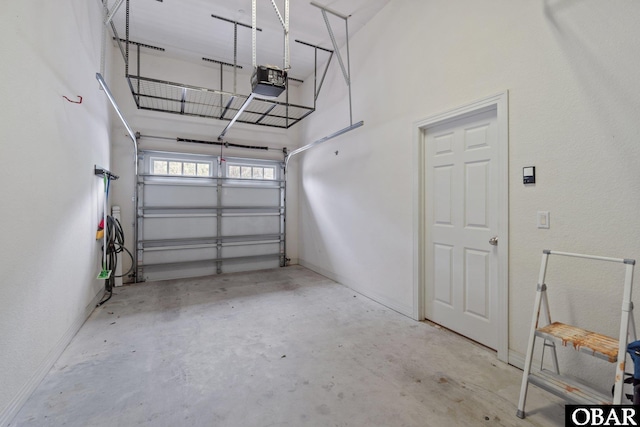 garage featuring a garage door opener and baseboards