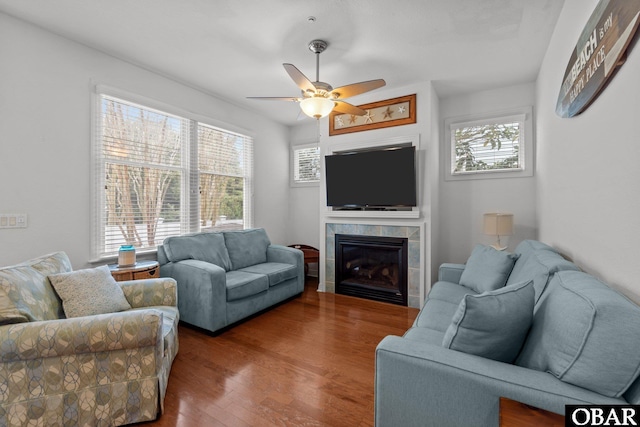 living room with a ceiling fan, wood finished floors, and a fireplace