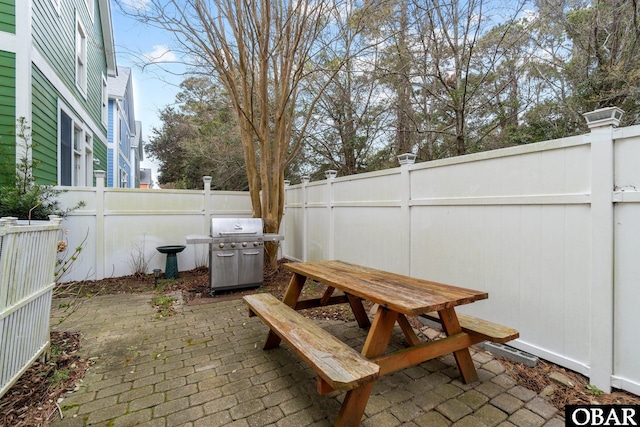 view of patio with a grill, outdoor dining area, and a fenced backyard