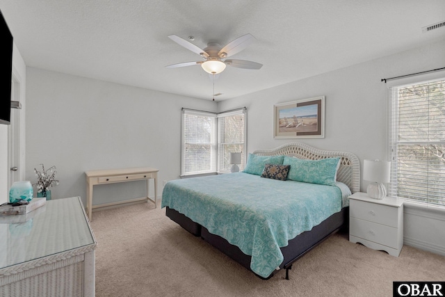 bedroom with visible vents, light colored carpet, and multiple windows