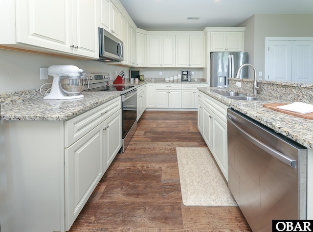 284 Old Swamp Rd, South Mills, NC 27976 - kitchen with stainless steel appliances, dark wood-style floors, white cabinetry, and light stone counters