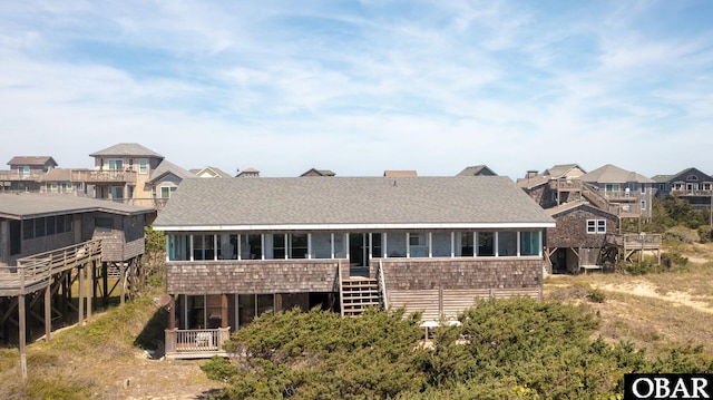 rear view of house with roof with shingles and a residential view