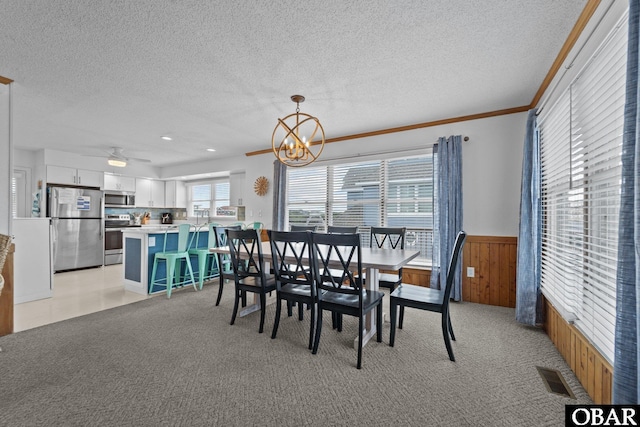 11 Pelican Watch Way Unit A/Lot11, Southern Shores, NC 27949 - dining area featuring a textured ceiling, a wainscoted wall, crown molding, a chandelier, and light colored carpet