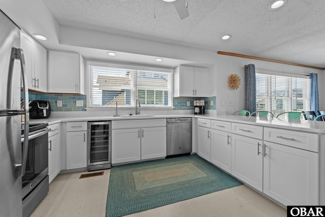 11 Pelican Watch Way Unit A/Lot11, Southern Shores, NC 27949 - kitchen featuring wine cooler, appliances with stainless steel finishes, a sink, healthy amount of natural light, and a textured ceiling