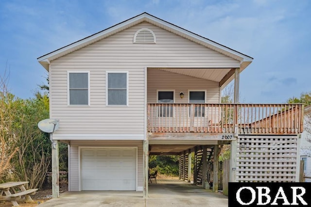 raised beach house featuring a porch, an attached garage, a carport, driveway, and stairs