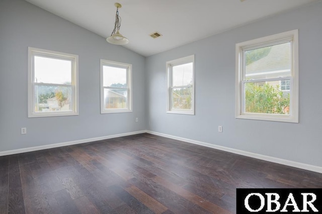 spare room with lofted ceiling, dark wood-style flooring, visible vents, and plenty of natural light