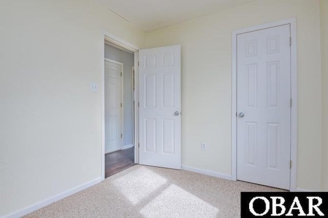 unfurnished bedroom with carpet floors and baseboards