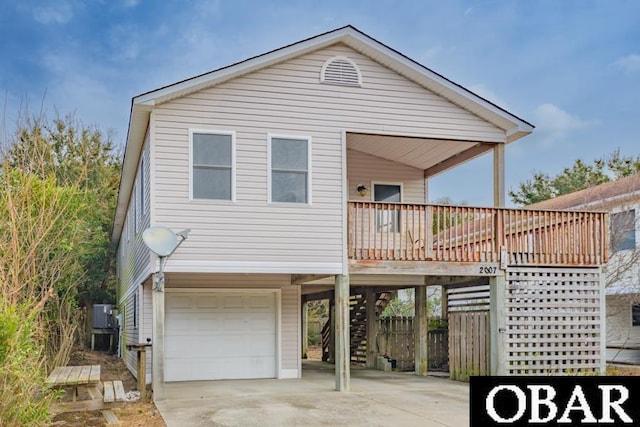 view of front facade featuring stairs, a carport, an attached garage, and driveway