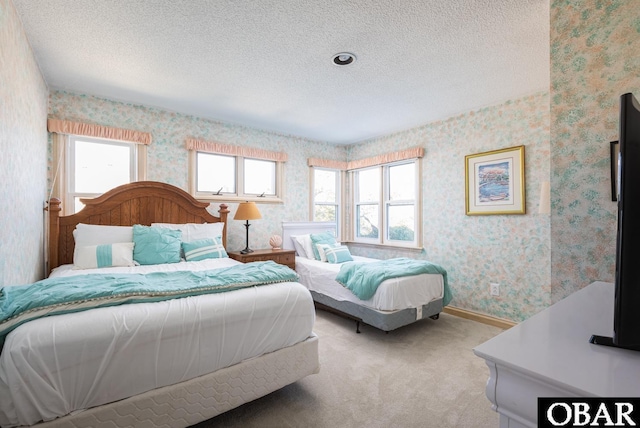 bedroom with a textured ceiling, baseboards, light colored carpet, and wallpapered walls