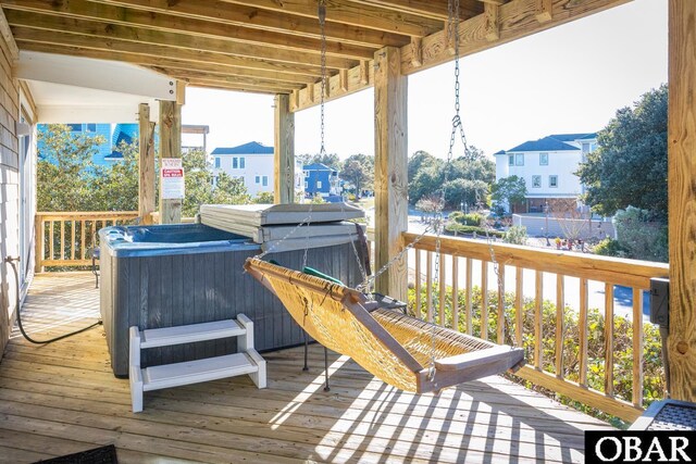 deck featuring a hot tub and a residential view