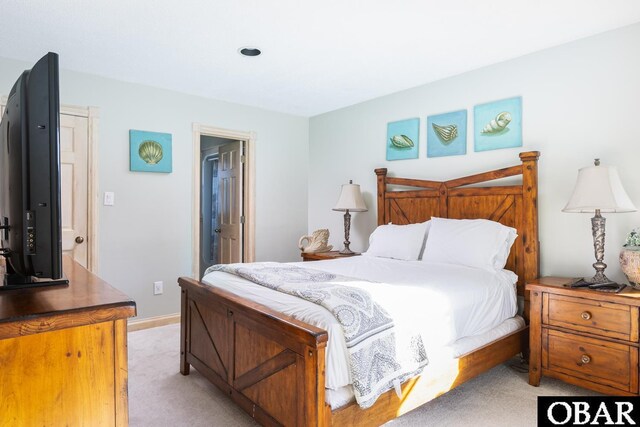 bedroom with baseboards and light colored carpet