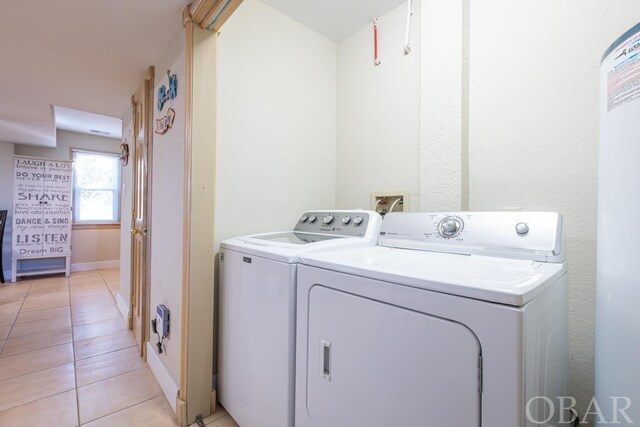 laundry room with laundry area, light tile patterned floors, baseboards, and independent washer and dryer