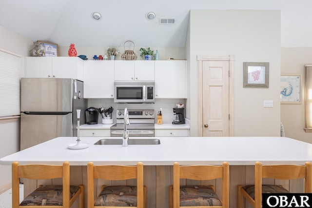 kitchen with white cabinets, visible vents, appliances with stainless steel finishes, and light countertops