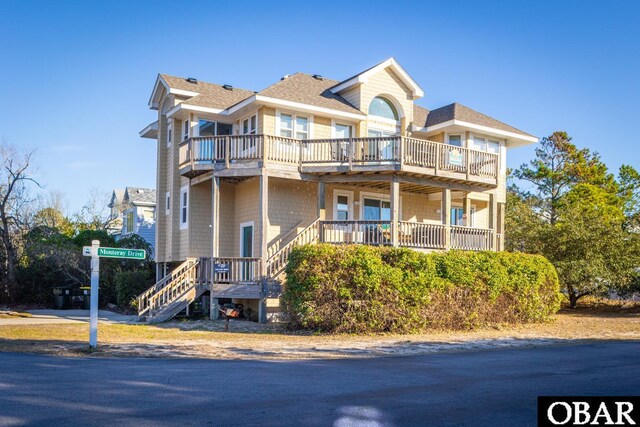 view of front of house featuring a shingled roof and stairs