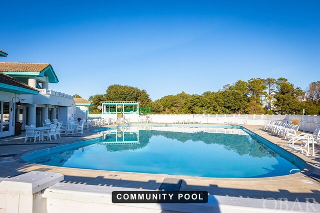 pool with a pergola, fence, and a patio