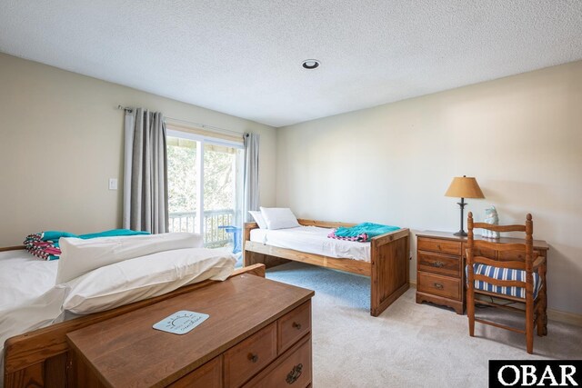 bedroom featuring light carpet and a textured ceiling