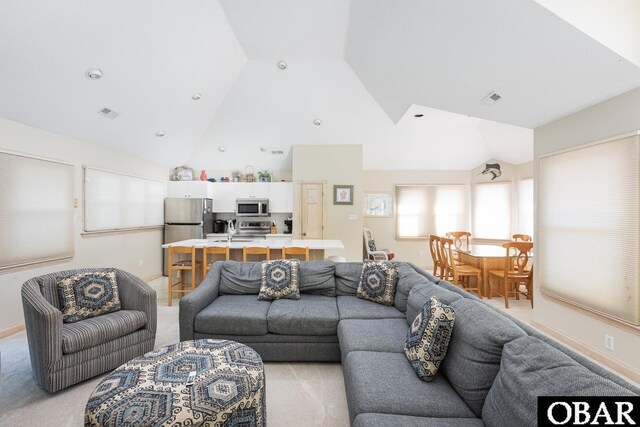 living area featuring high vaulted ceiling, baseboards, and visible vents