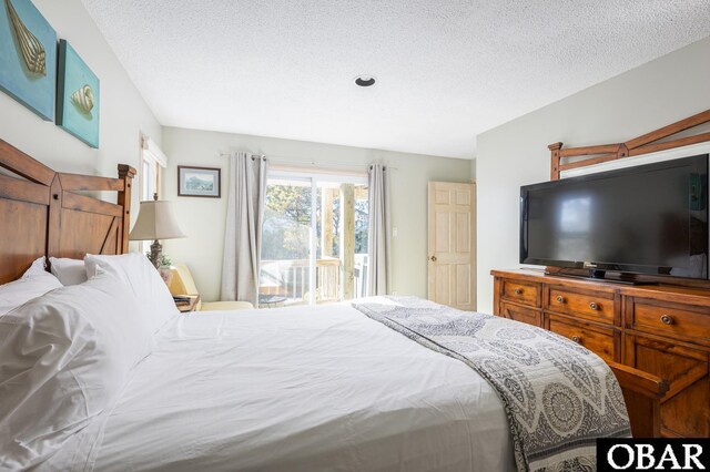 bedroom featuring access to exterior and a textured ceiling