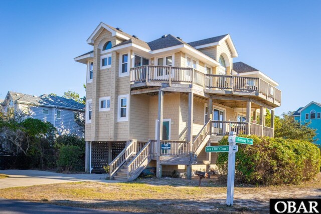 exterior space featuring a shingled roof and stairs