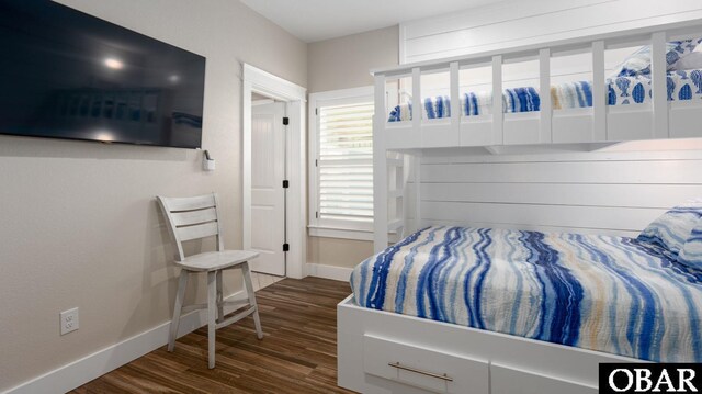 bedroom with baseboards and dark wood-type flooring