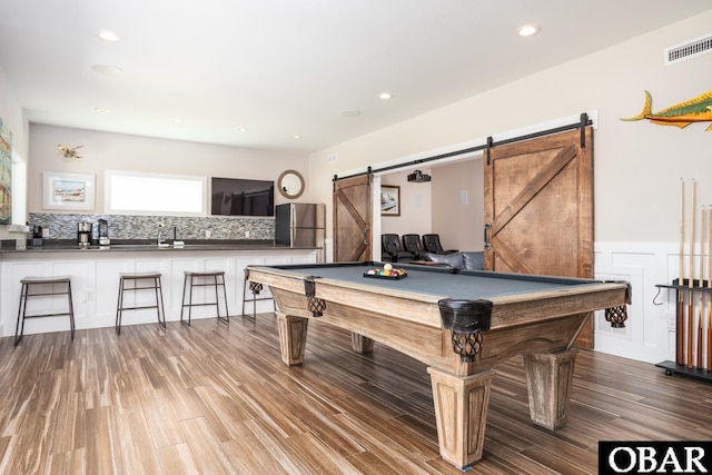 playroom with recessed lighting, wood finished floors, visible vents, and a barn door