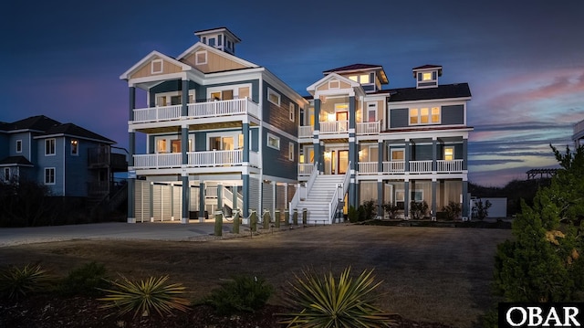 beach home featuring a carport, board and batten siding, stairway, and a balcony