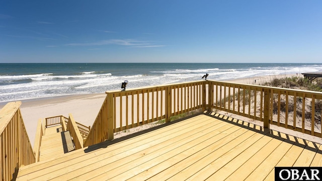 wooden terrace featuring a view of the beach and a water view