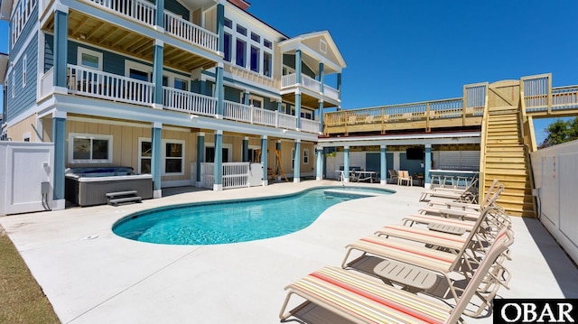 pool with stairway, a patio, a hot tub, and fence