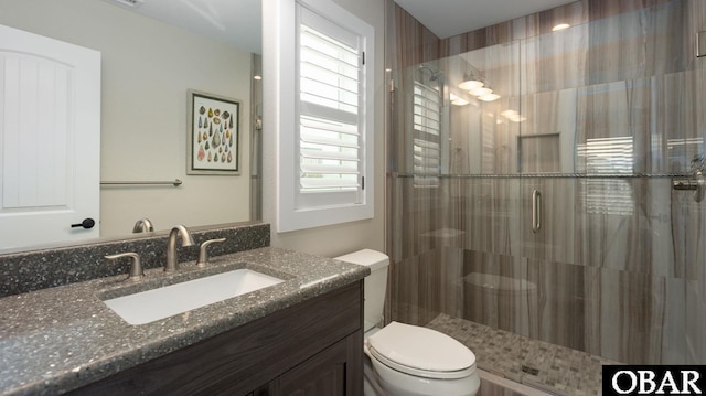 bathroom featuring a stall shower, vanity, and toilet