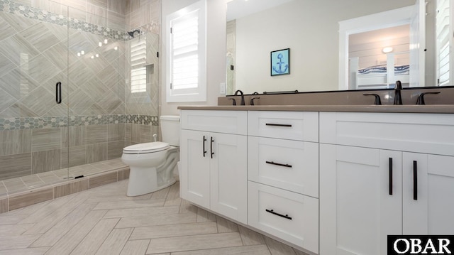 bathroom with a sink, a shower stall, toilet, and double vanity