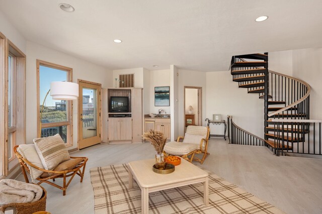 living room with stairway, recessed lighting, and light wood-style flooring